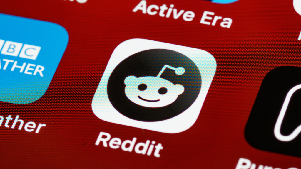 Close-up of the Reddit app icon on a smartphone screen, referencing popular ADHD skincare discussions in online communities.