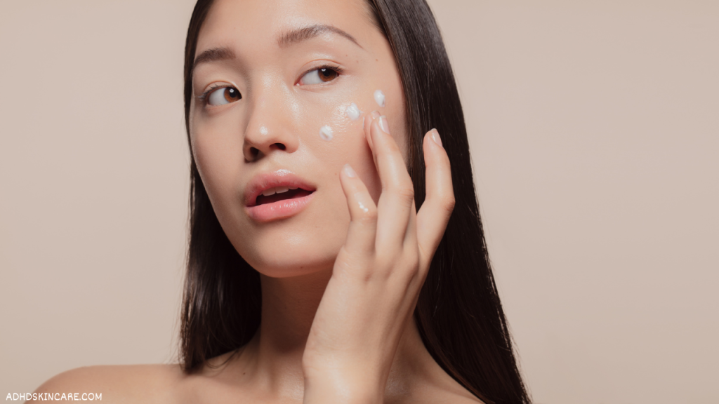 A woman with oily skin applying moisturizer which is step two in a 4-step skincare routine for oily skin