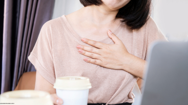 A woman holding chest in discomfort