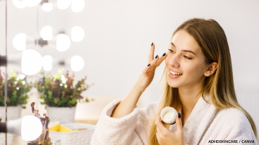 Woman applying moisturizer at vanity, routine habit for ADHD skincare.